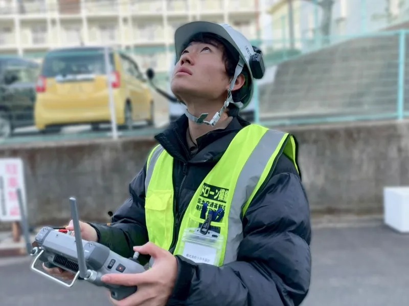 ドローンを操縦する作業員の姿