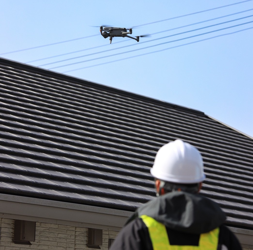 ドローンを操縦する作業員の姿